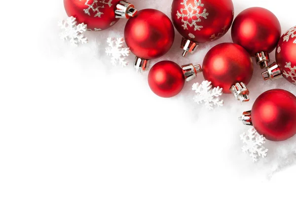 Röda julgranskulor i snön på vit — Stockfoto