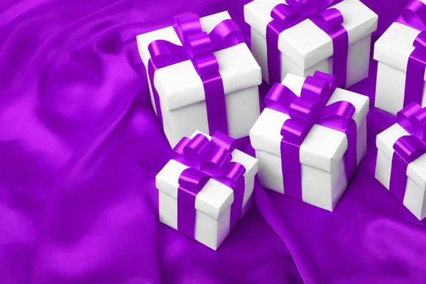 Подарок на фиолетовом фоне атласа — стоковое фото