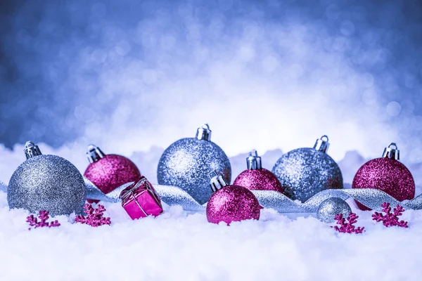 Christmas ornament in snow on glitter background — Stock Photo, Image