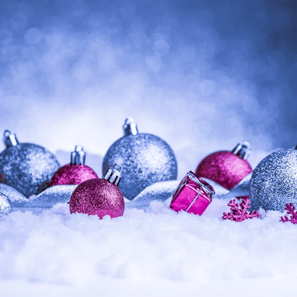 Ornamento de Natal na neve no fundo brilho — Fotografia de Stock