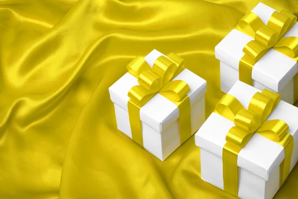 Geschenk auf gelbem Satin Hintergrund — Stockfoto