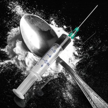 Drug syringe and cooked heroin on spoon clipart