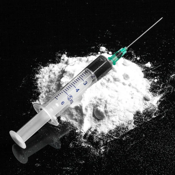 Drogas de cocaína amontoadas com seringa — Fotografia de Stock
