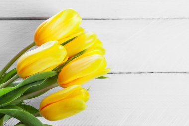 Tahta bir yüzeyde sarı laleler