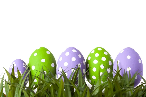Fila de huevos de Pascua en hierba verde fresca — Foto de Stock