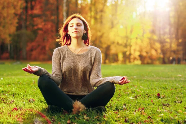 Ung attraktiv kvinna meditera i park. — Stockfoto
