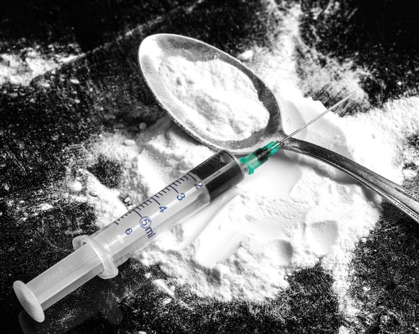 Drogenspritze und gekochtes Heroin auf Löffel — Stockfoto