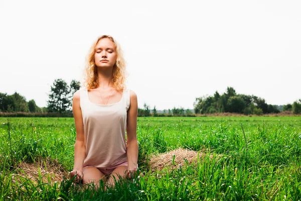 Mooie vrouw mediteren in zomer park — Stockfoto