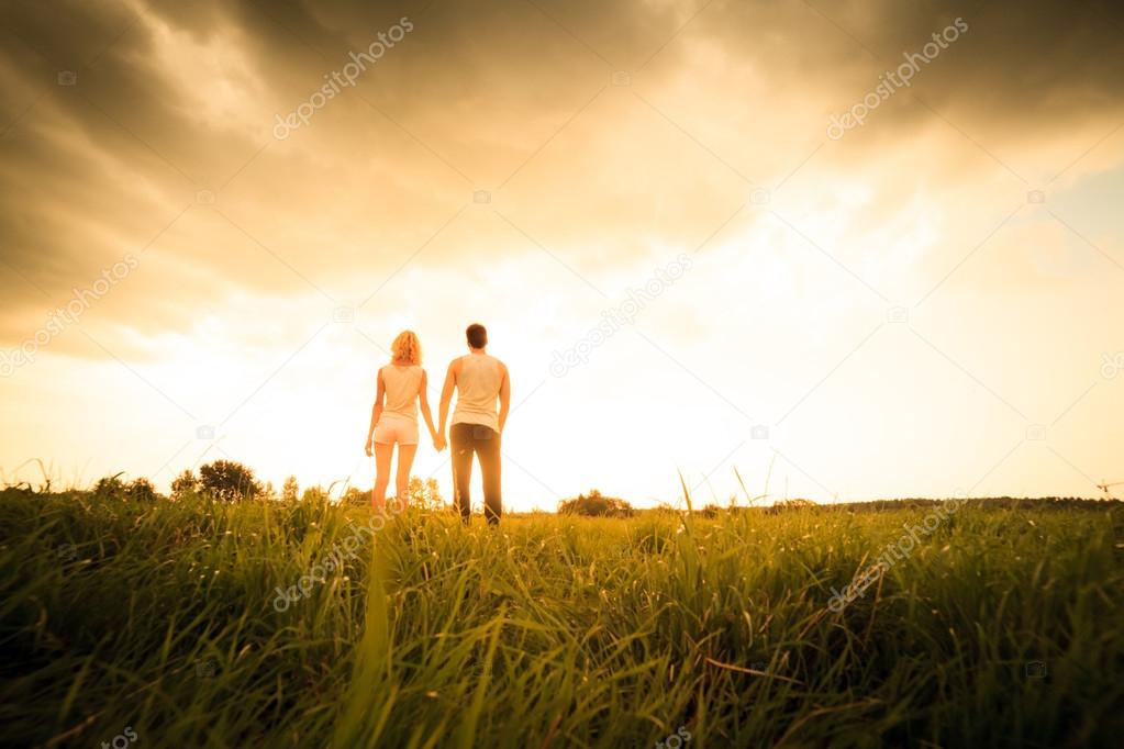 man and woman rest in the field