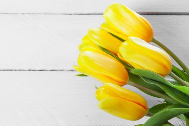 Tahta bir yüzeyde sarı laleler