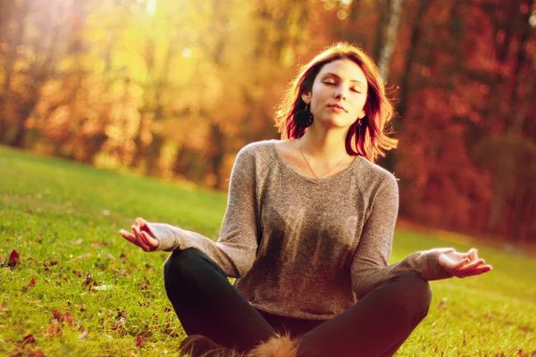 Giovane ragazza che medita nel parco autunnale — Foto Stock