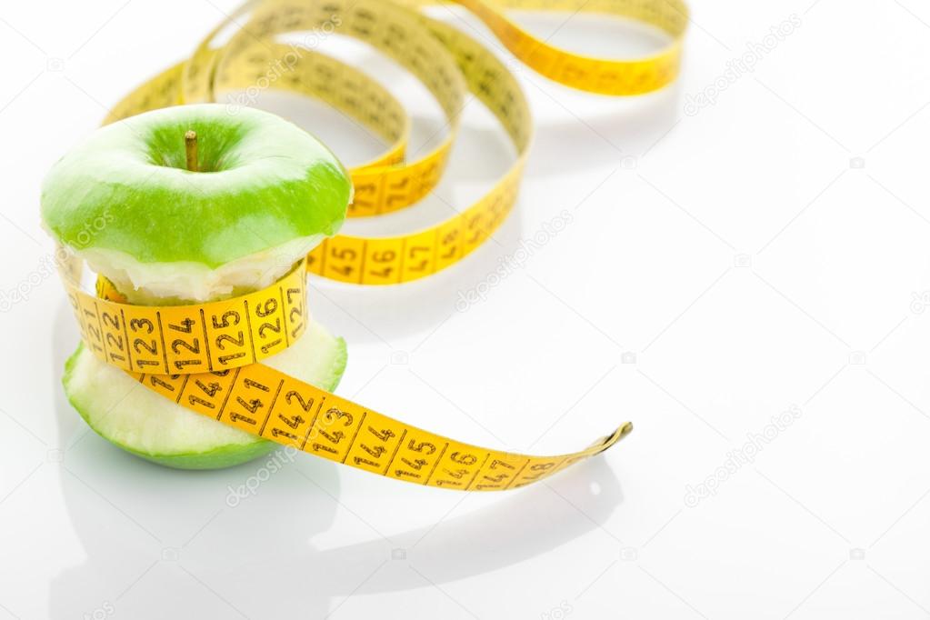 Green apple core and measuring tape