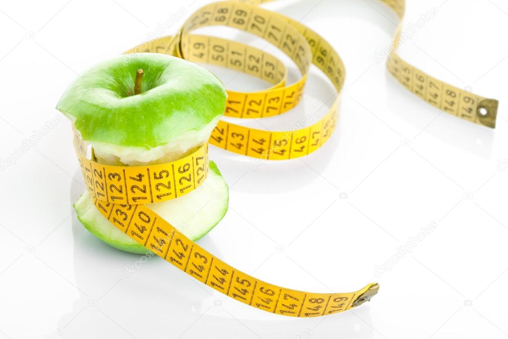 Green apple core and measuring tape