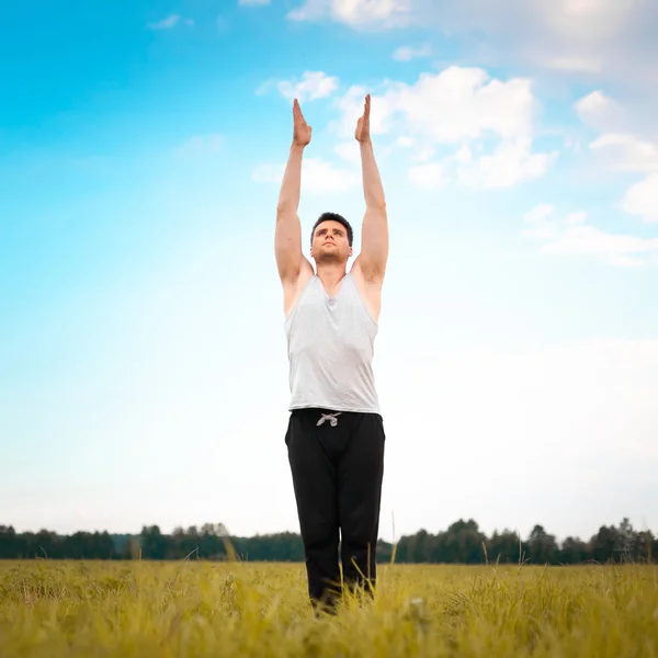 Ung man gör yoga i park — Stockfoto