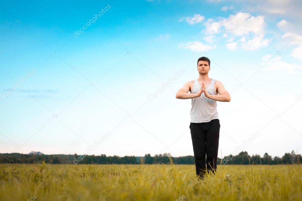 Young man doing yoga in park