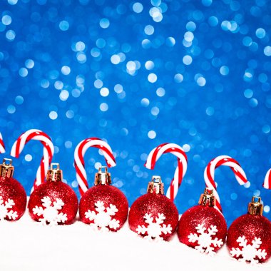 Noel kırmızı topları mavi parlak zemin üzerine karda