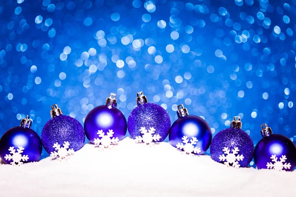 蓝色的圣诞球在雪地上闪烁背景 — 图库照片