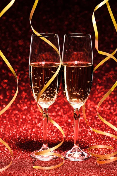 Glasses of champagne with yellow holidays ribbons — Stock Photo, Image