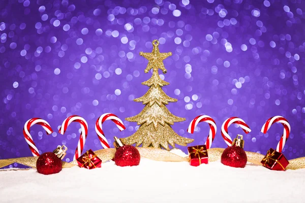 Χριστουγεννιάτικο στολίδι στο χιόνι σε φόντο λάμψη — Φωτογραφία Αρχείου