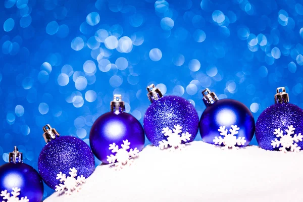 Boules rouges de Noël dans la neige sur fond bleu paillettes — Photo