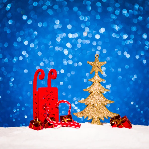 Рождественская елка и конфеты в снегу на голубом фоне блесток — стоковое фото