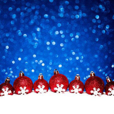 Noel kırmızı topları mavi parlak zemin üzerine karda