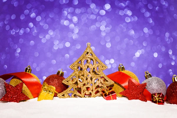 Рождественский орнамент в снегу на фоне блесток — стоковое фото