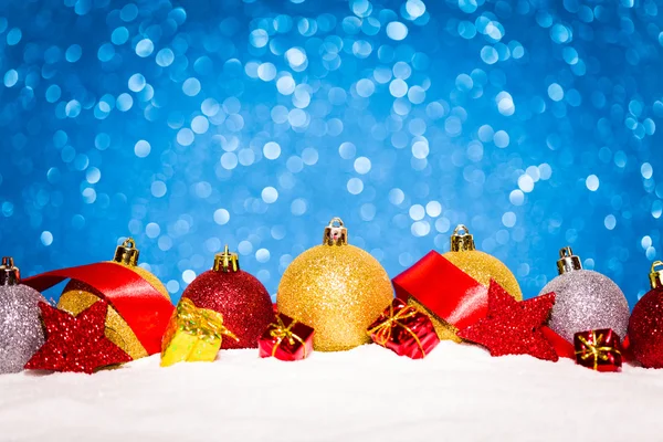 Ornamento de Natal na neve no fundo brilho — Fotografia de Stock