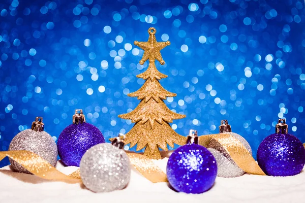 圣诞树，糖果放在雪上蓝色光圈背景 — 图库照片