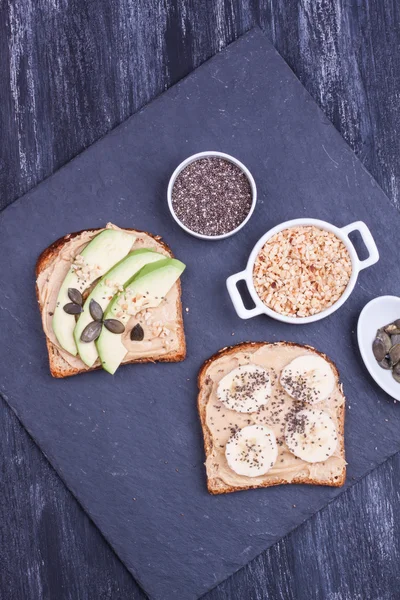 Pan con mantequilla de maní y plátano, aguacate —  Fotos de Stock