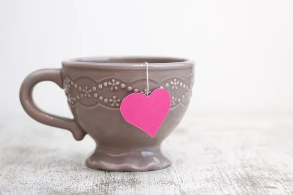 Copa con bolsa de té en forma de corazón —  Fotos de Stock