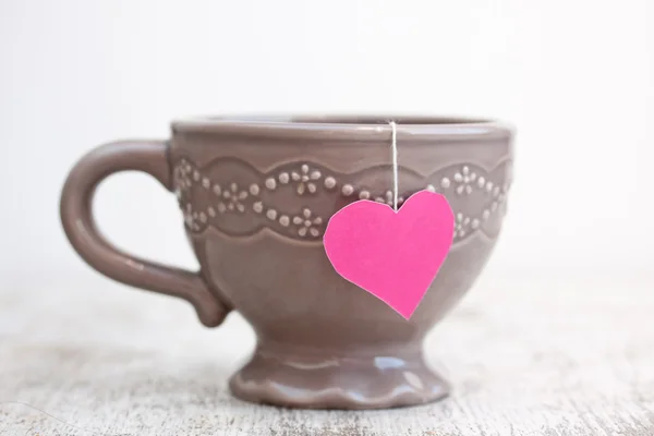 Pohár s sáček čaje ve tvaru srdce — Stock fotografie