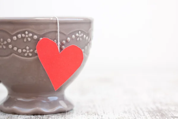 Cup with heart shaped tea bag — Stock Photo, Image