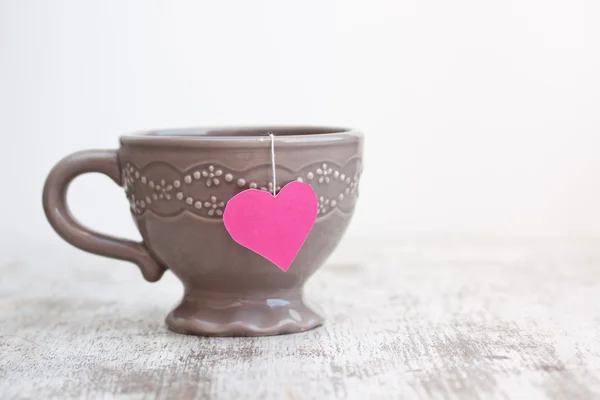 Cup with heart shaped tea bag — Stock Photo, Image