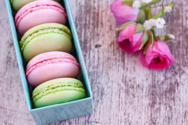 Färgglada macaroons och rosor — Stockfoto