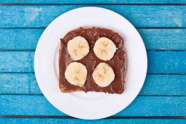 Bread with chocolate spread and banana — Stock Photo, Image