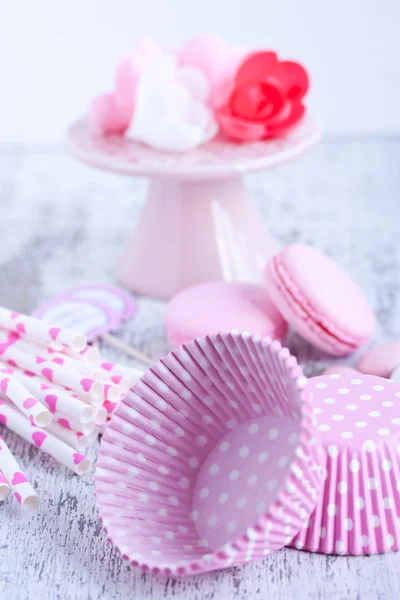 Dulces recubiertos de azúcar, tazas para hornear magdalenas, macarrones, pajitas rosadas — Foto de Stock