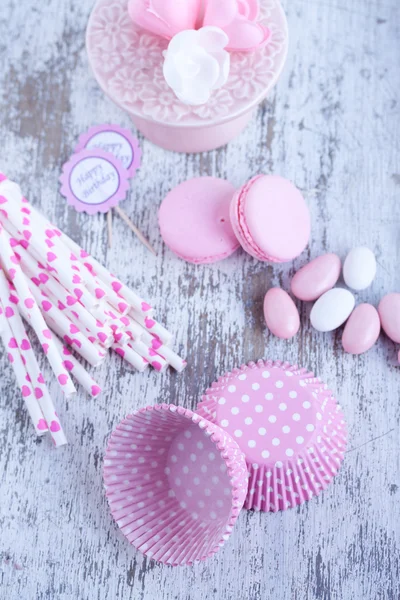 Dulces recubiertos de azúcar, tazas para hornear magdalenas, macarrones, pajitas rosadas — Foto de Stock