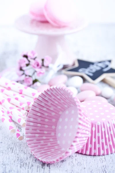 Dulces recubiertos de azúcar, tazas para hornear magdalenas, macarrones, pajitas rosadas — Foto de Stock