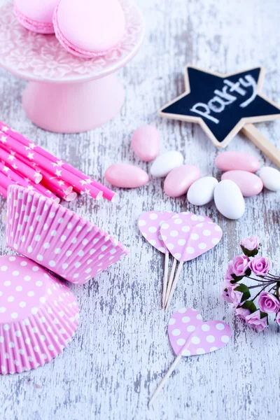 Dulces recubiertos de azúcar, tazas para hornear magdalenas, macarrones, pajitas rosadas — Foto de Stock