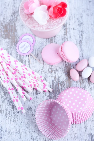 Dulces recubiertos de azúcar, tazas para hornear magdalenas, macarrones, pajitas rosadas — Foto de Stock