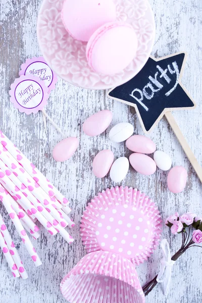 Sugar coated candies, cupcake baking cups, macaroons, pink straws — Stock Photo, Image