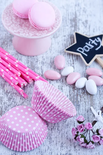 Sugar coated candies, cupcake baking cups, macaroons, pink straws — Stock Photo, Image