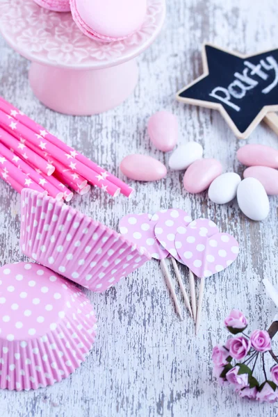 Sugar coated candies, cupcake baking cups, macaroons, pink straws Royalty Free Stock Images