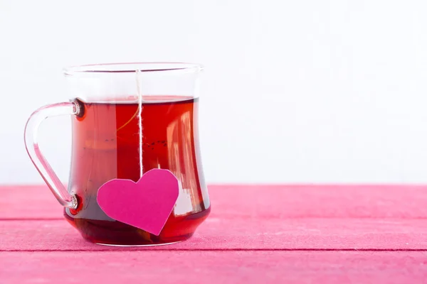 Black tea with heart shaped tea bag — Stock Photo, Image