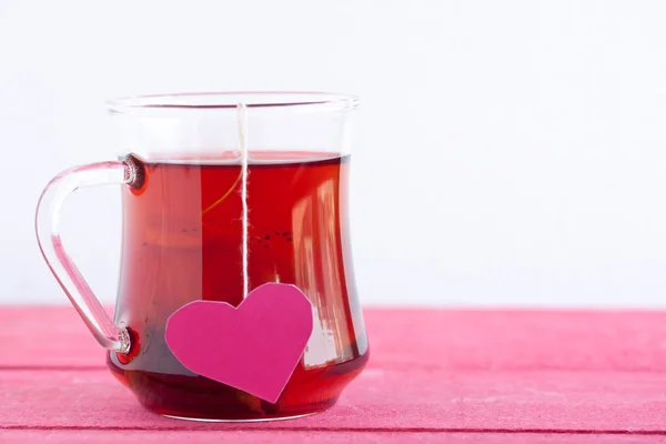 Chá preto com saco de chá em forma de coração — Fotografia de Stock