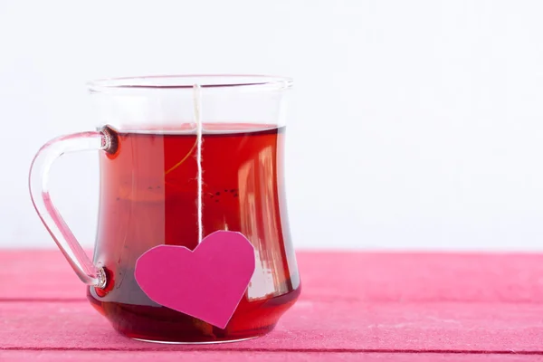 Té negro con bolsa de té en forma de corazón —  Fotos de Stock