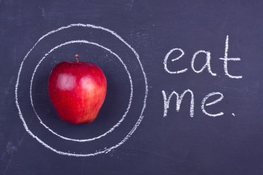 bir kara tahta üzerinde kırmızı elma