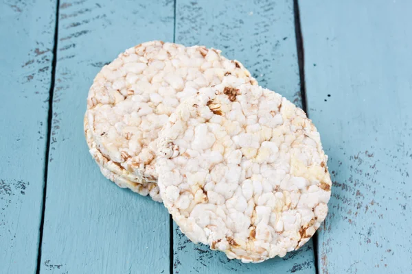 Galleta de arroz sobre un fondo de madera verde — Foto de Stock