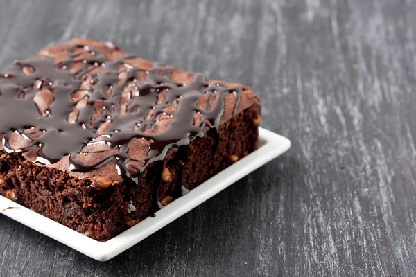 Brownie cake on a black wooden background — Stock Photo, Image